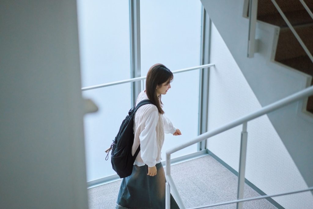 ドーミーあすと長町の階段を降りる女性
