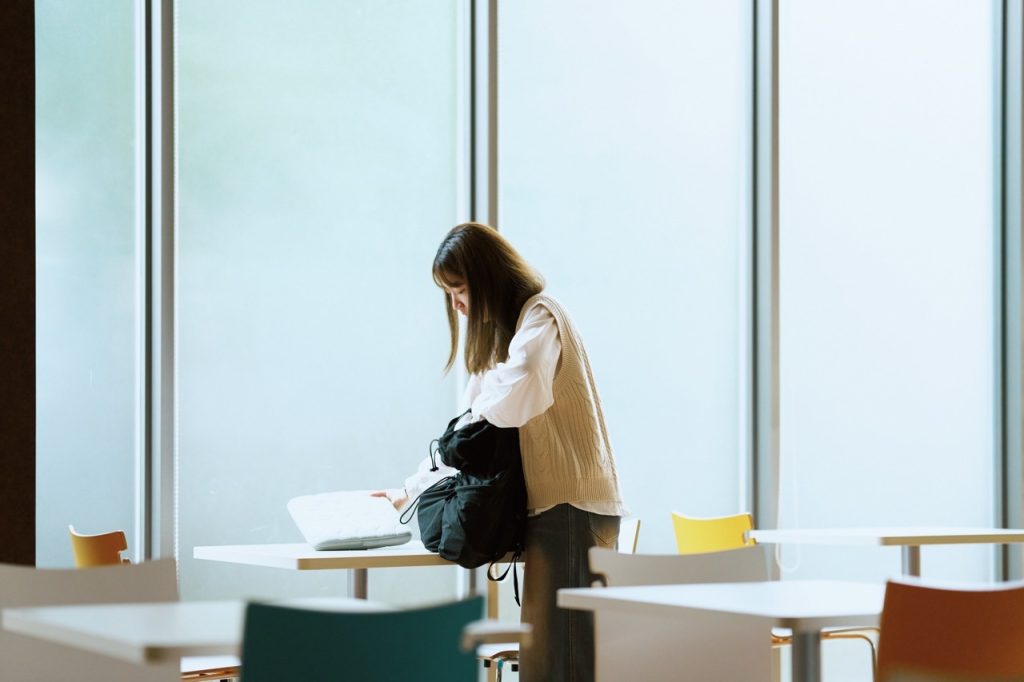 食堂で学校に行く支度をする女性